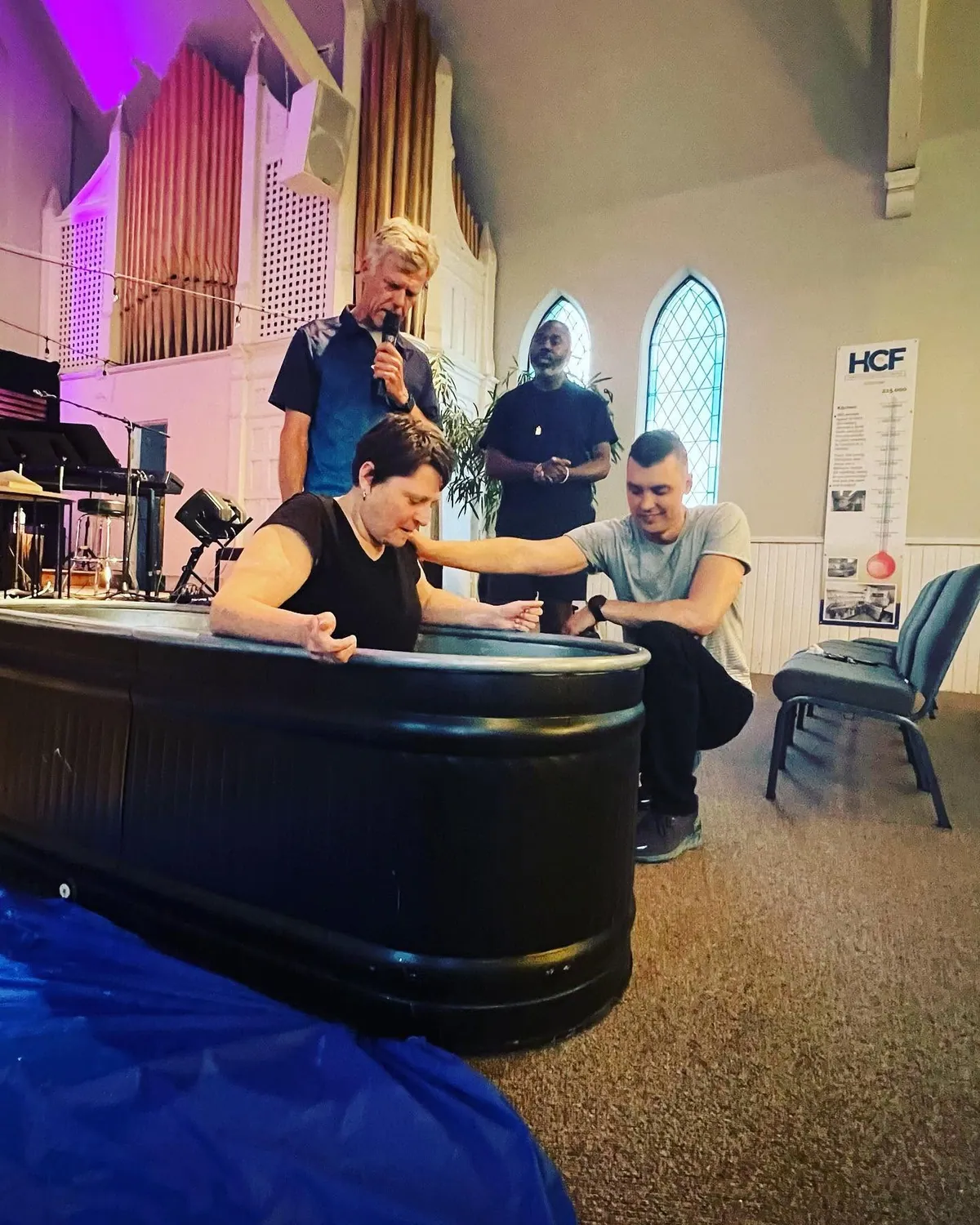 A new believer being baptised in a church baptism tank